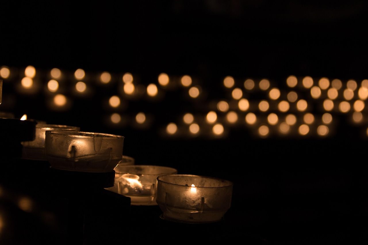 a lot of lit up candles, in a dark room