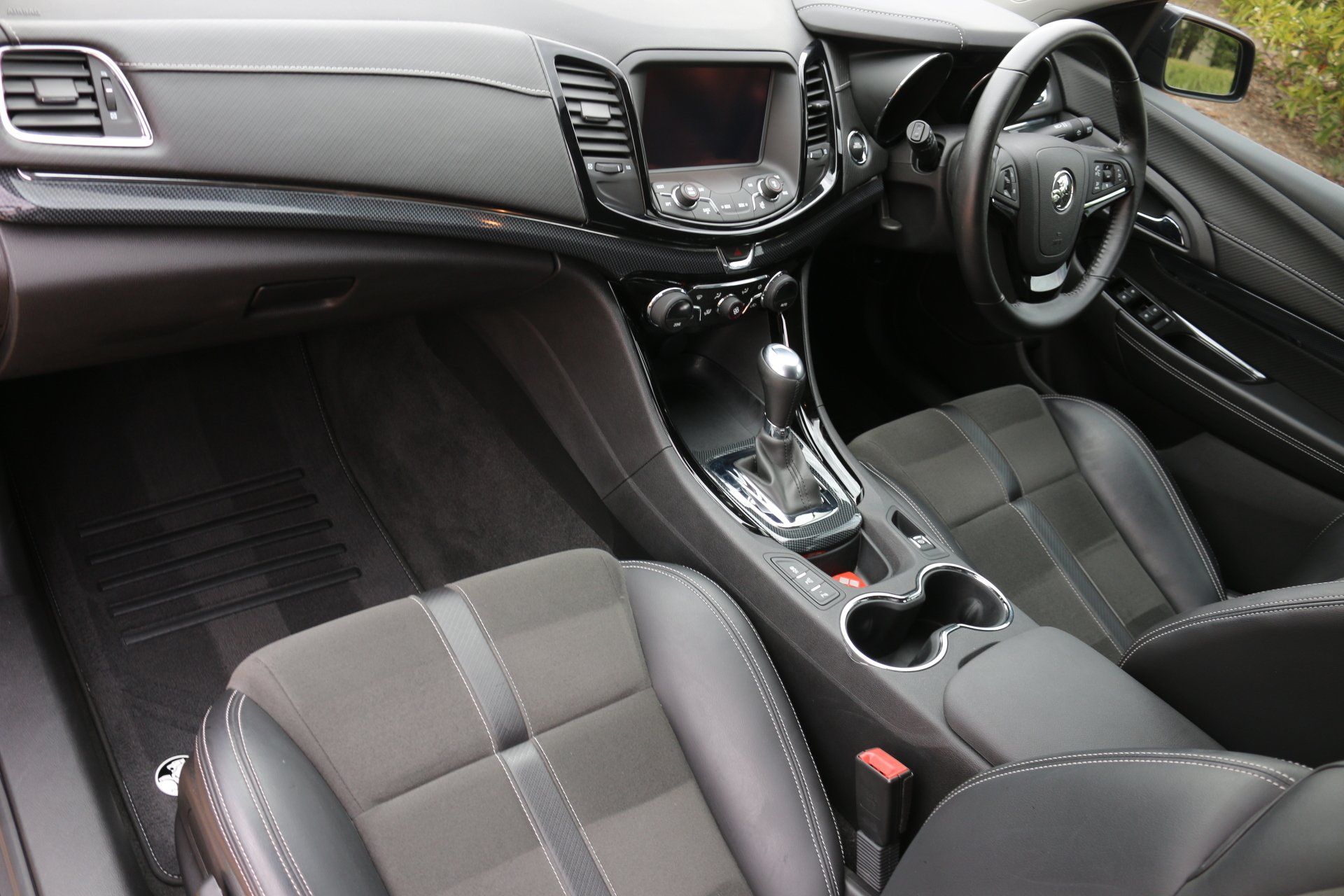 The interior of a car with black seats and a steering wheel