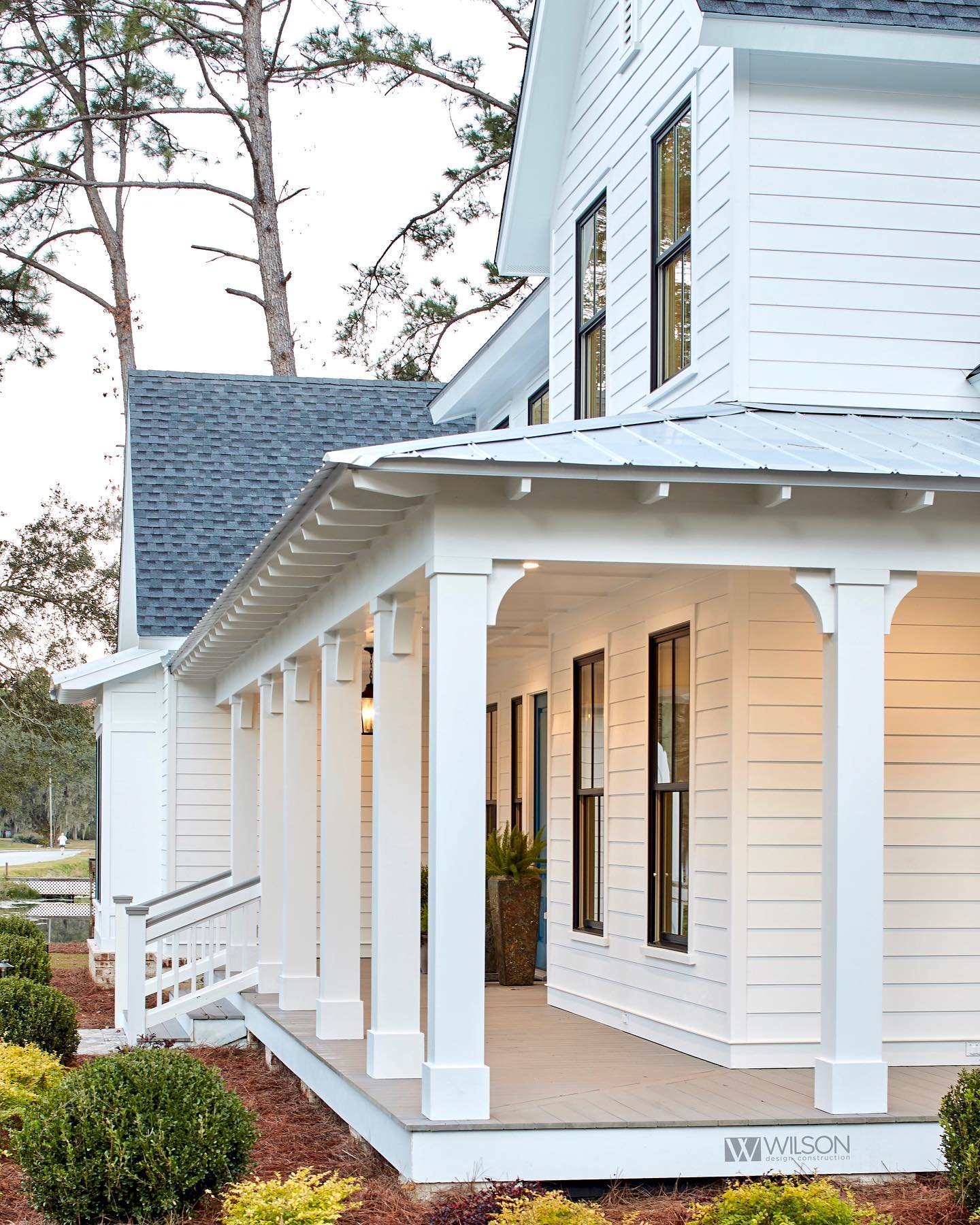 A white house with a porch and a blue roof