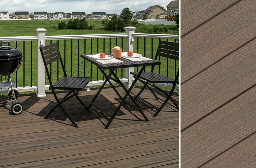 A wooden deck with a table and chairs and a grill