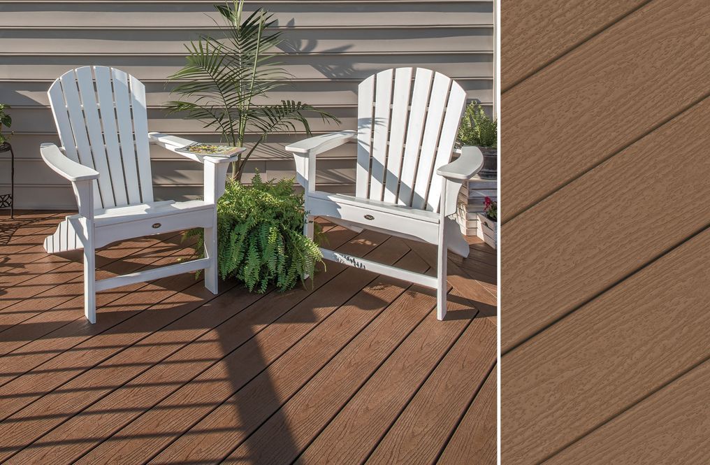 Two white adirondack chairs are sitting on a wooden deck.