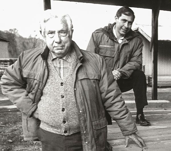 A black and white photo of two men standing next to each other