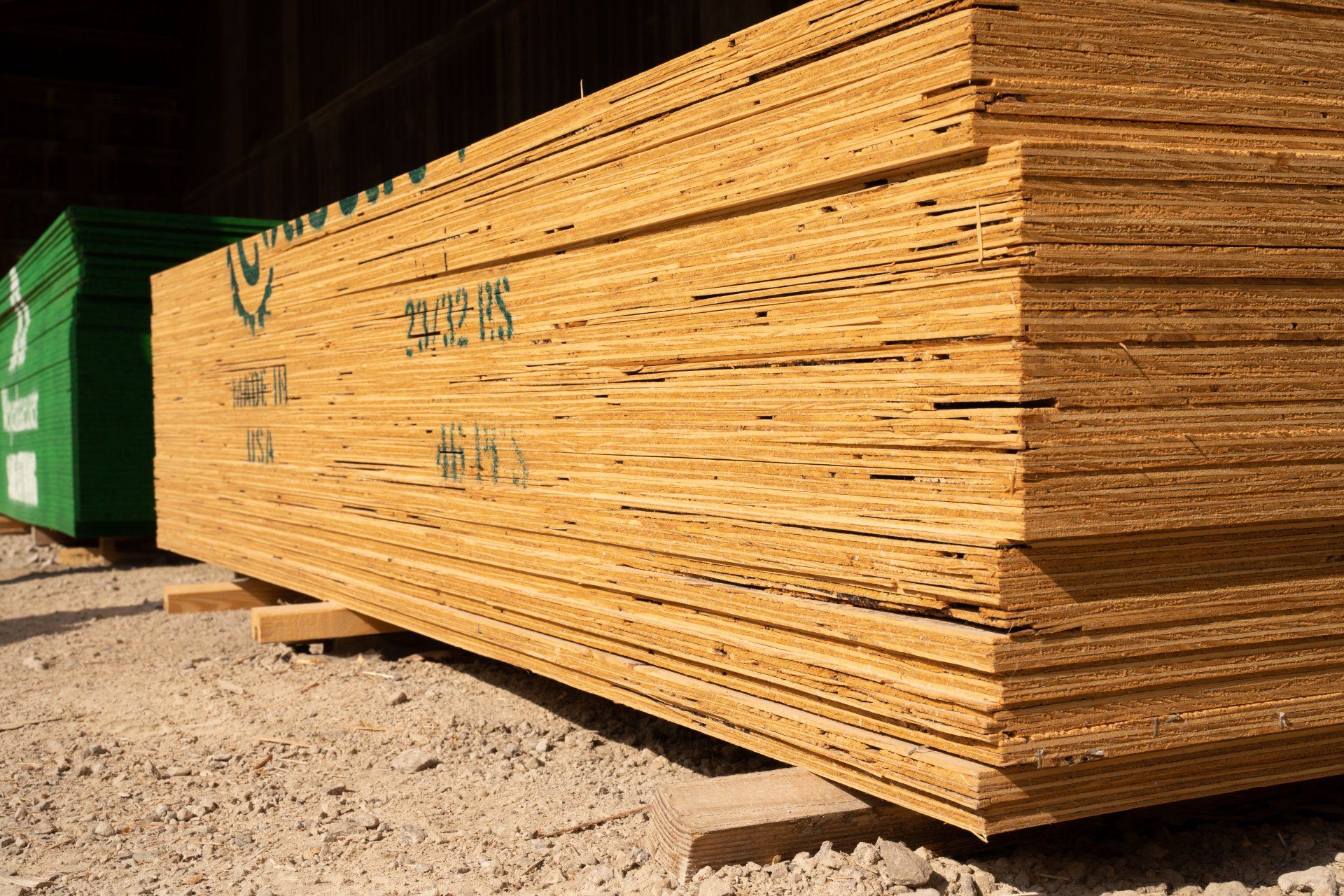 A stack of plywood is sitting on top of a pile of dirt.