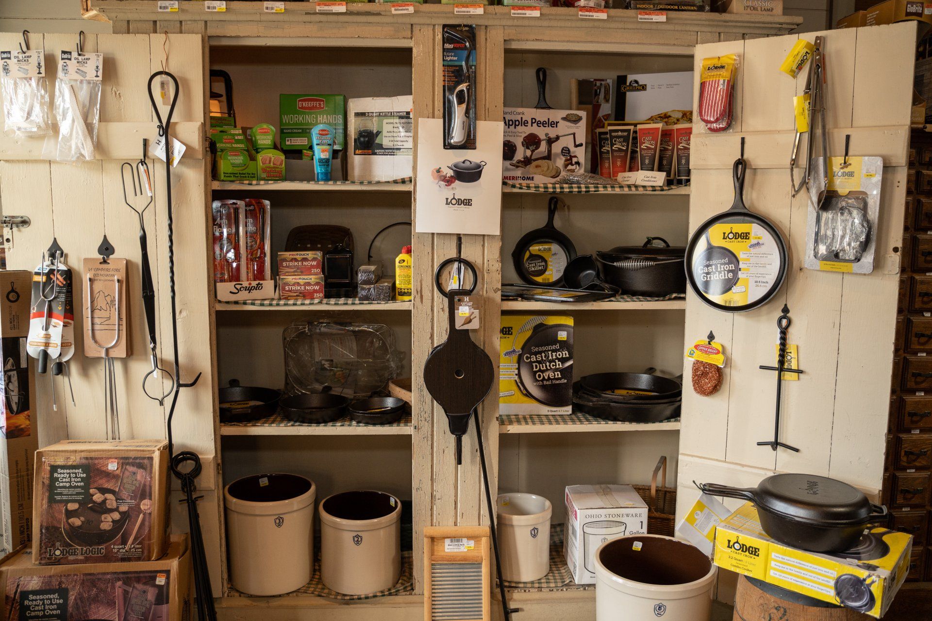 A cabinet filled with lots of pots and pans.