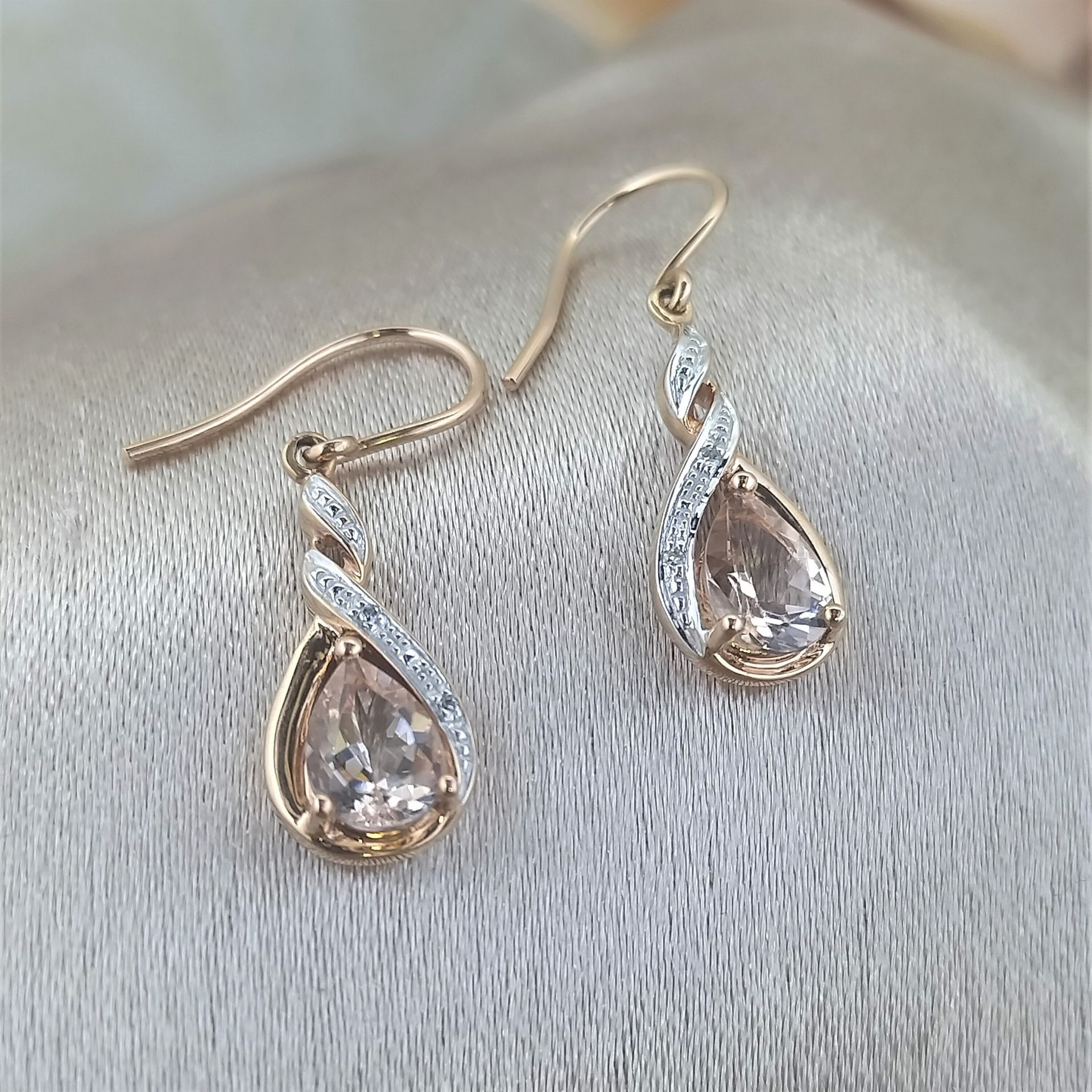 A pair of earrings are sitting on a white cloth