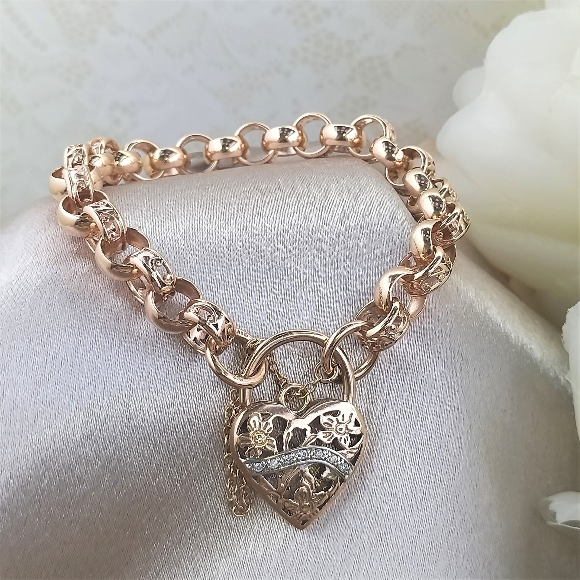 A gold bracelet with a heart shaped padlock on it