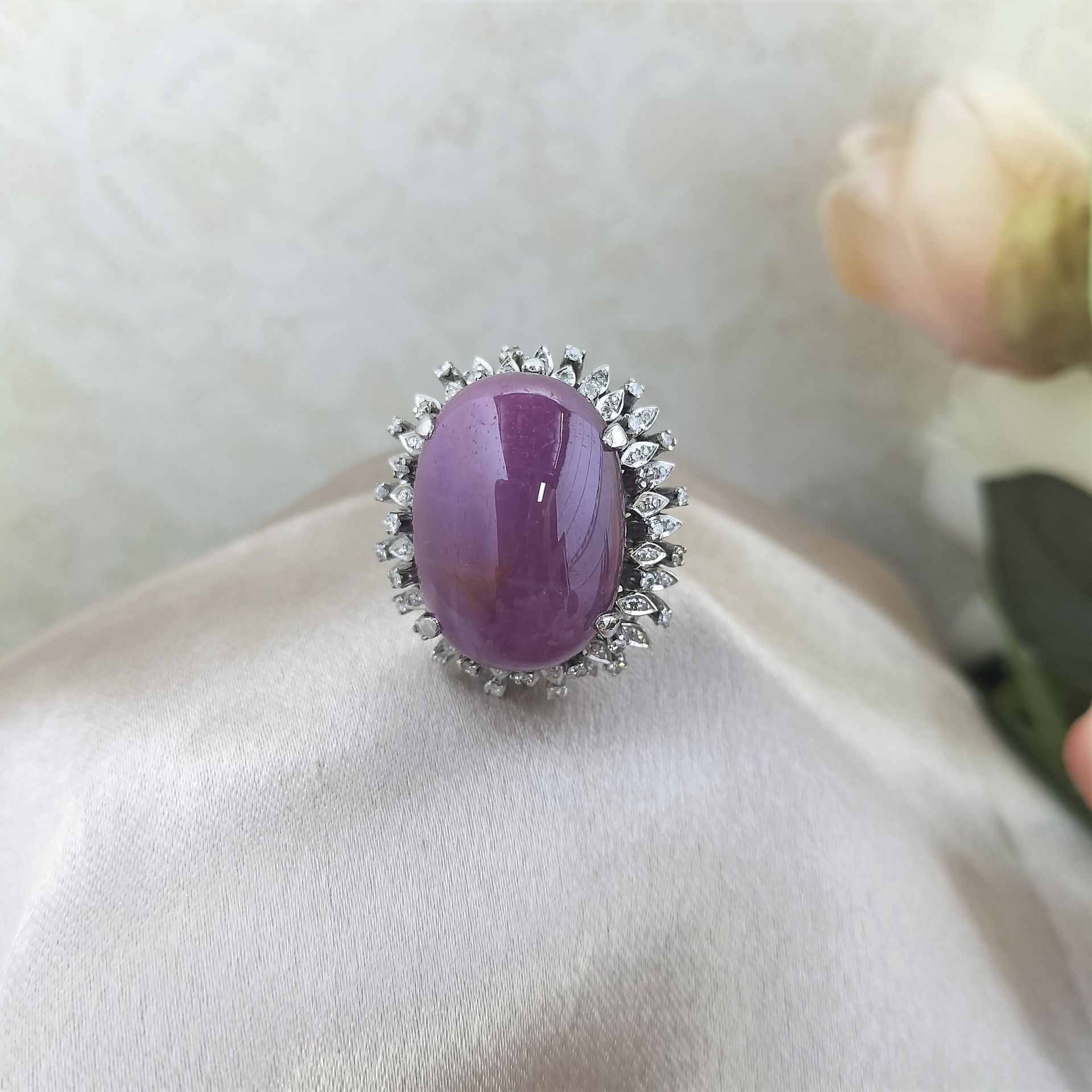 A silver ring with a purple stone and diamonds