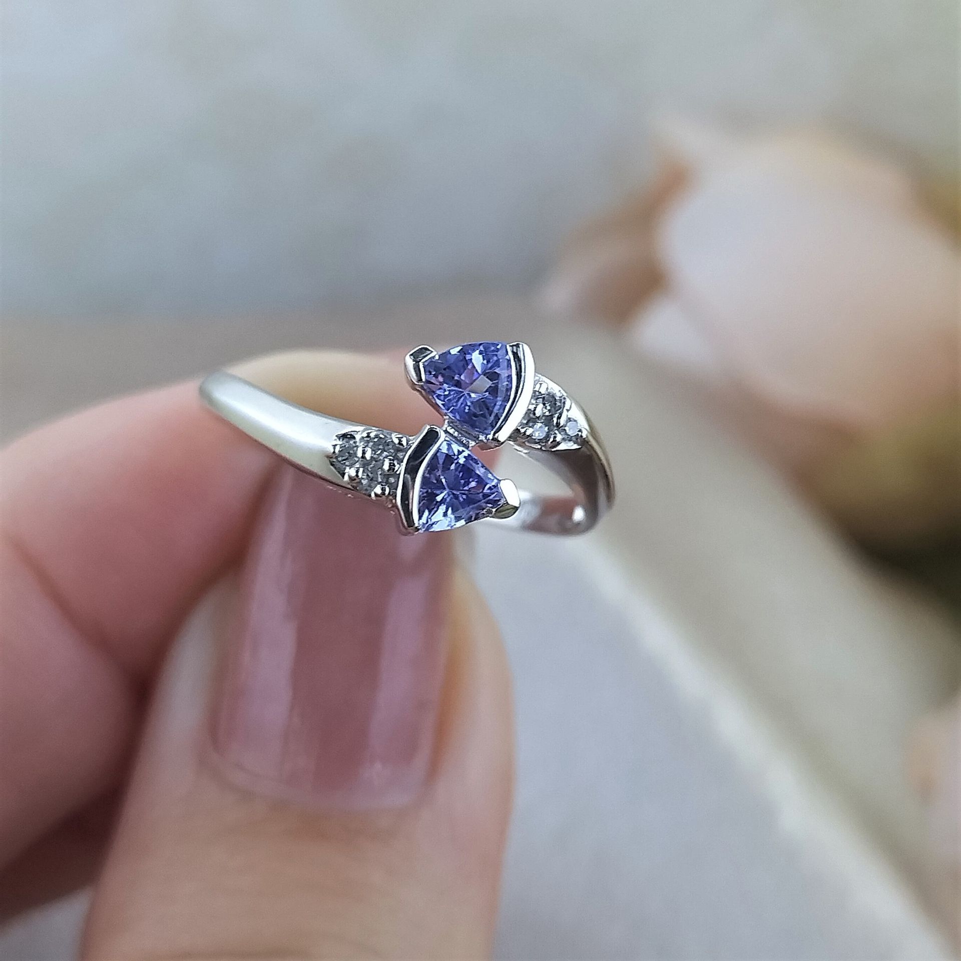 A person is holding a ring with two hearts on it