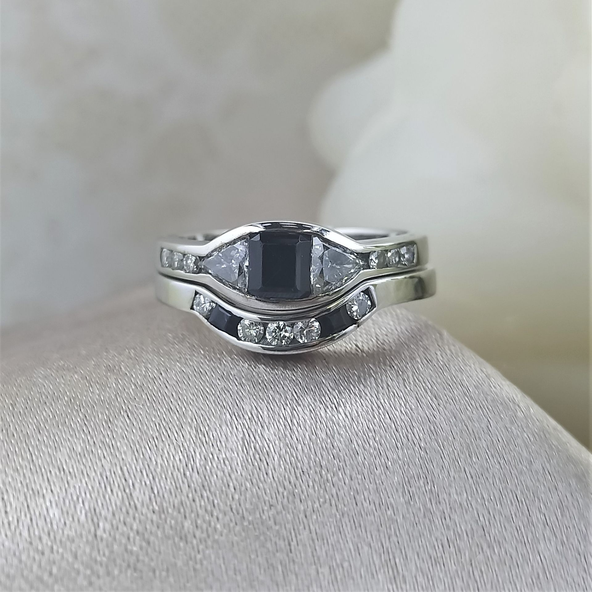 A silver ring with a black stone and diamonds