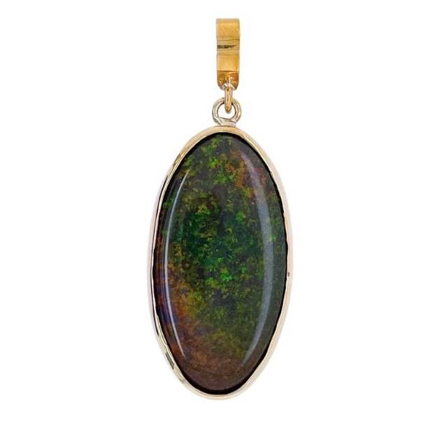 A gold pendant with a green stone in it