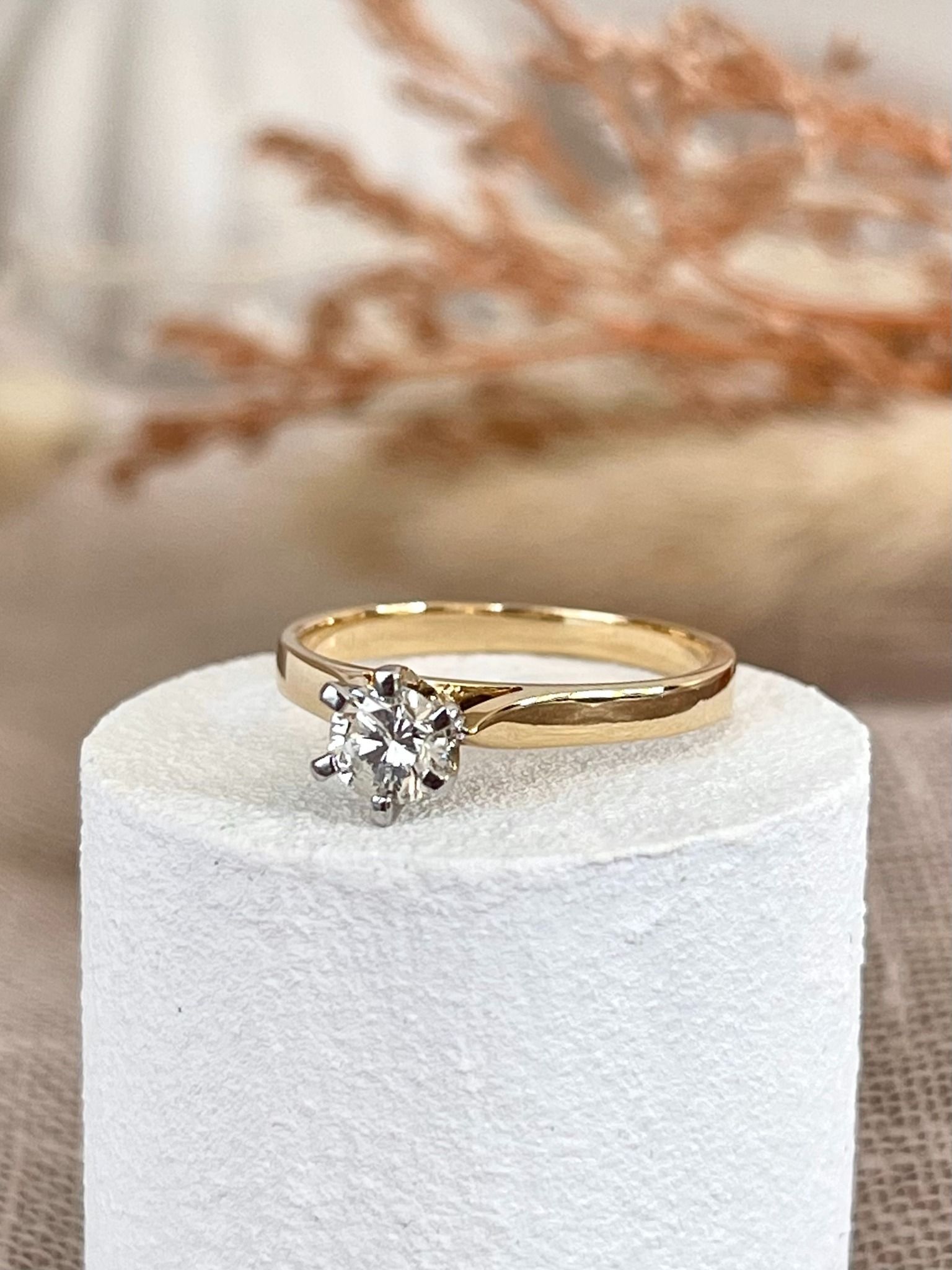 An engagement ring is sitting on top of a piece of toilet paper.