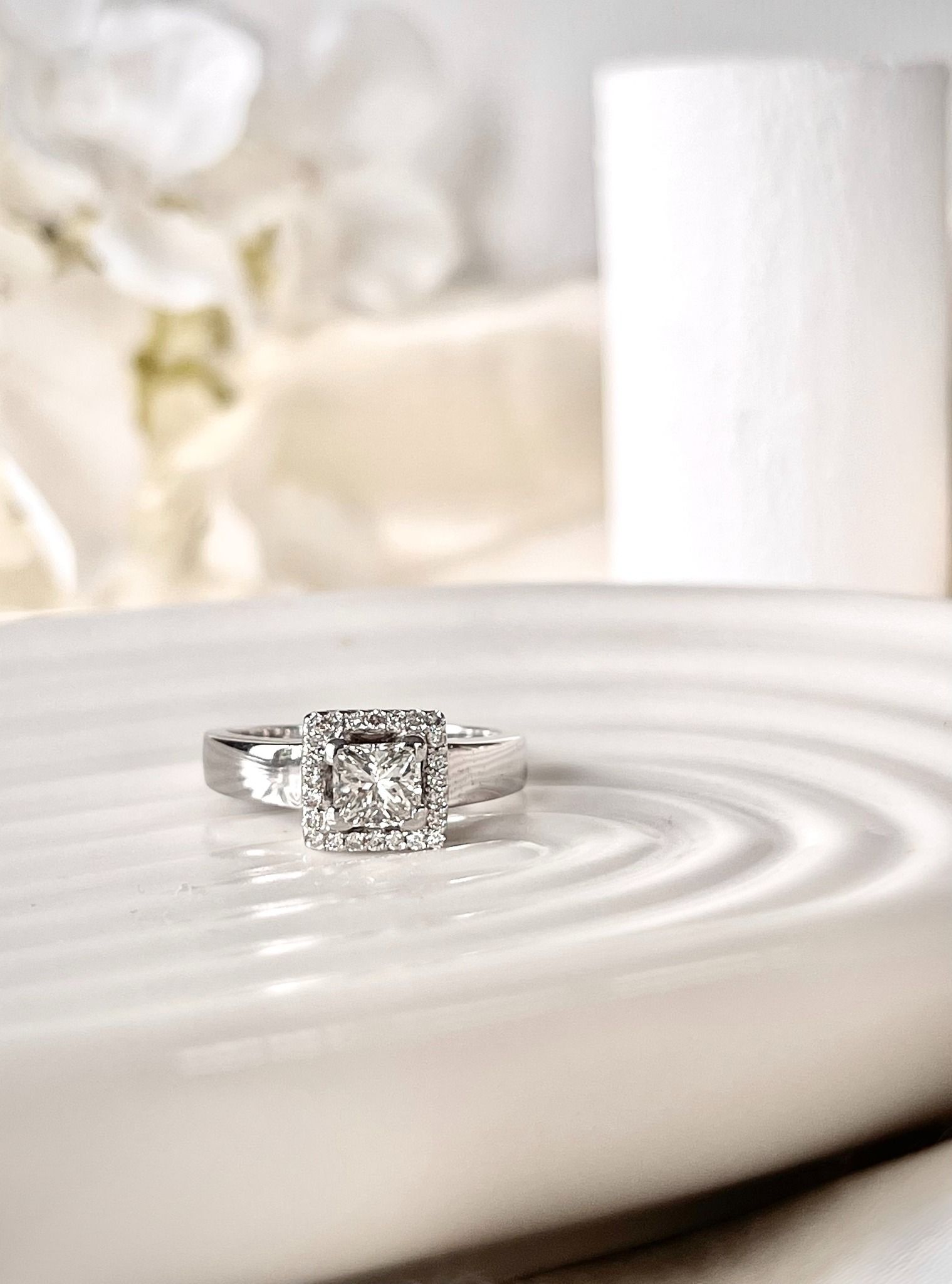 A diamond ring is sitting on top of a white plate.