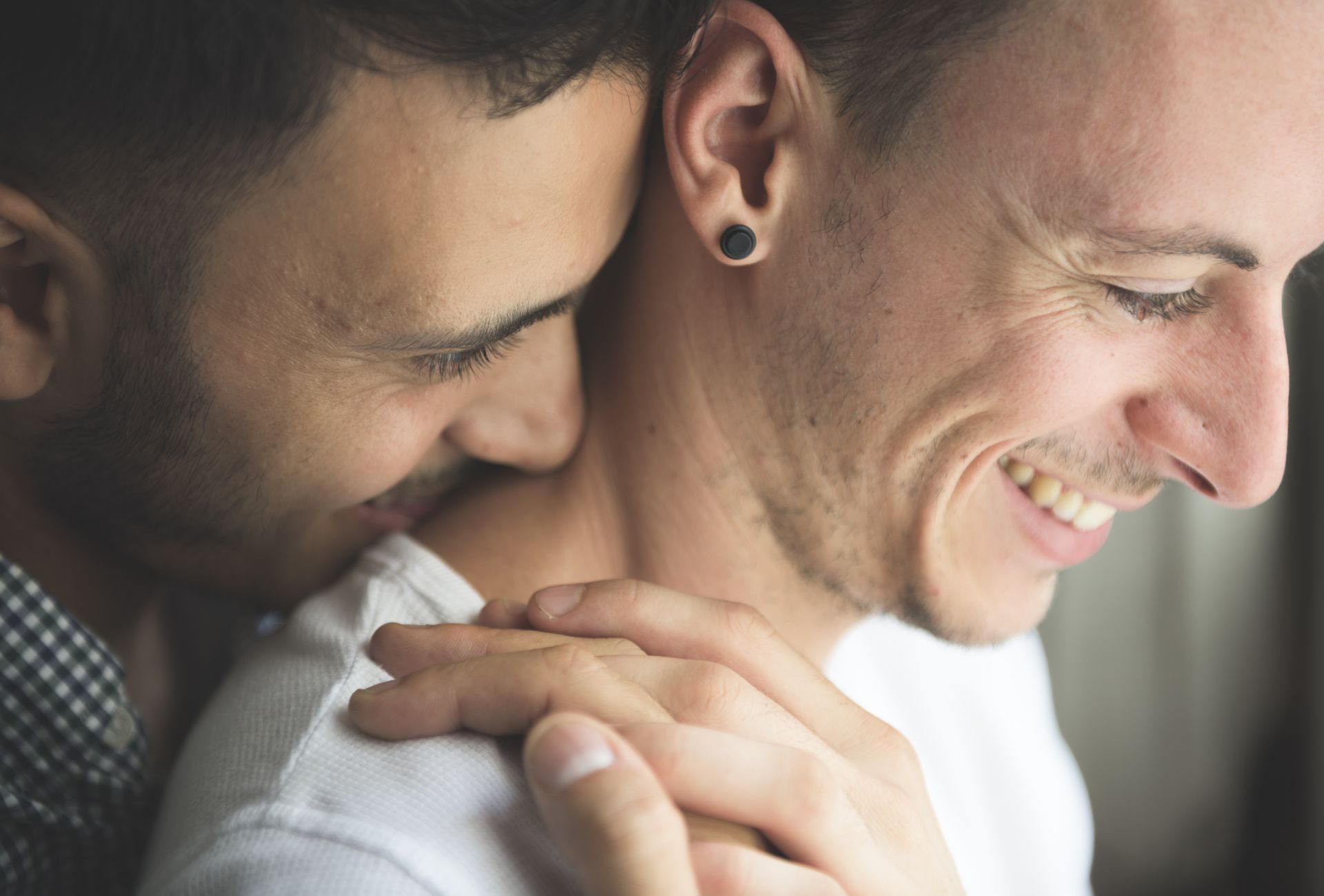 a couple of men are hugging each other and smiling .