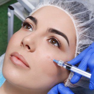 Young woman receiving plastic surgery injection on her face,