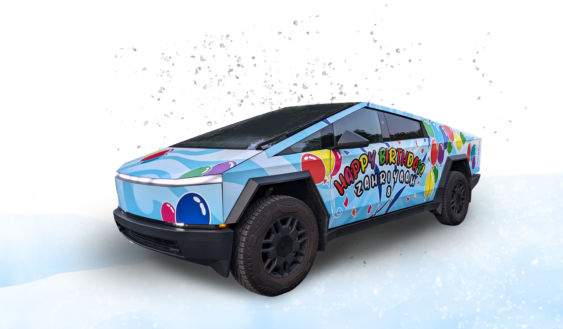 Cybertruck with colorful birthday design on a grassy hill.