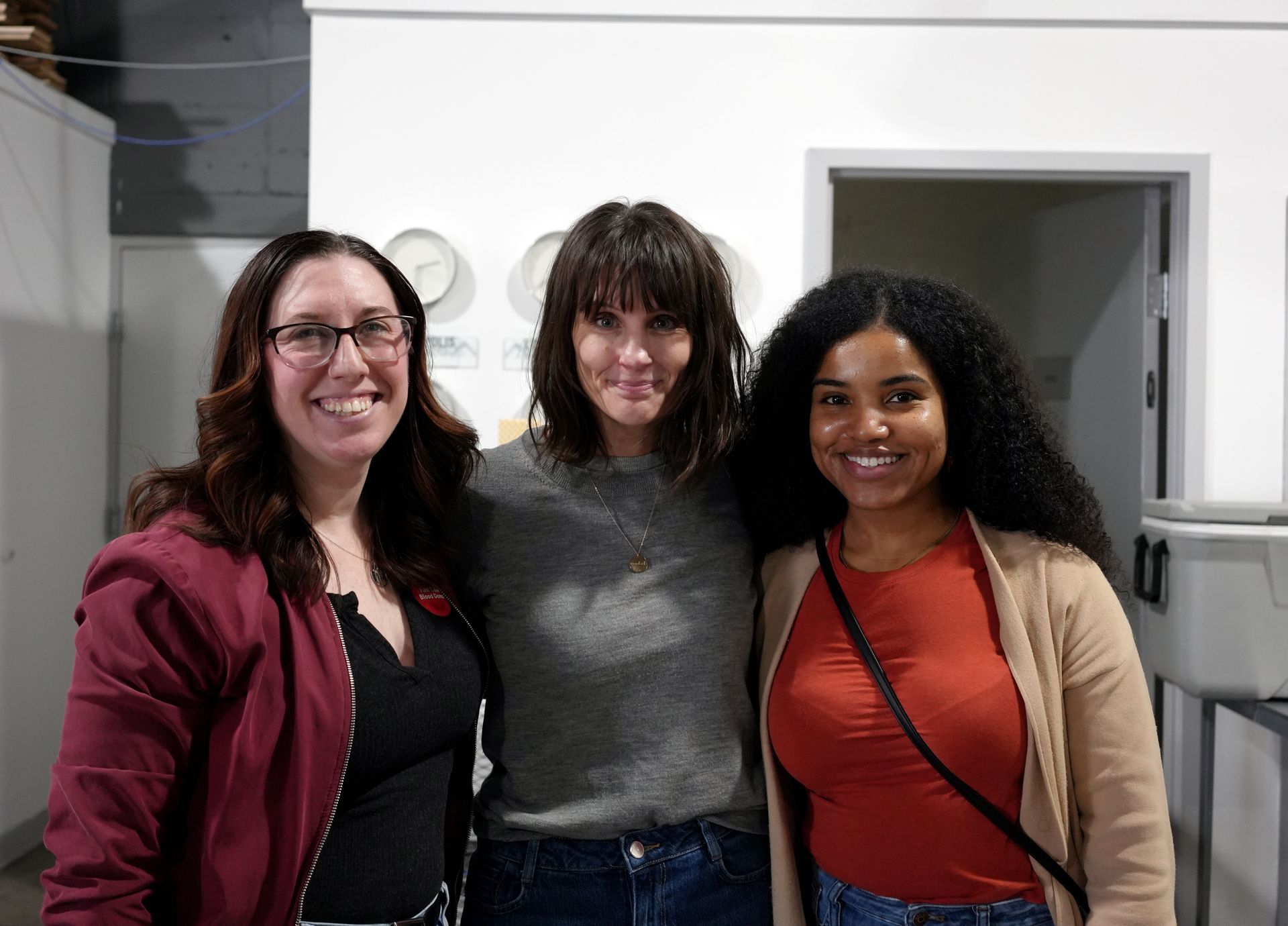 Three women are posing for a picture together in a room.