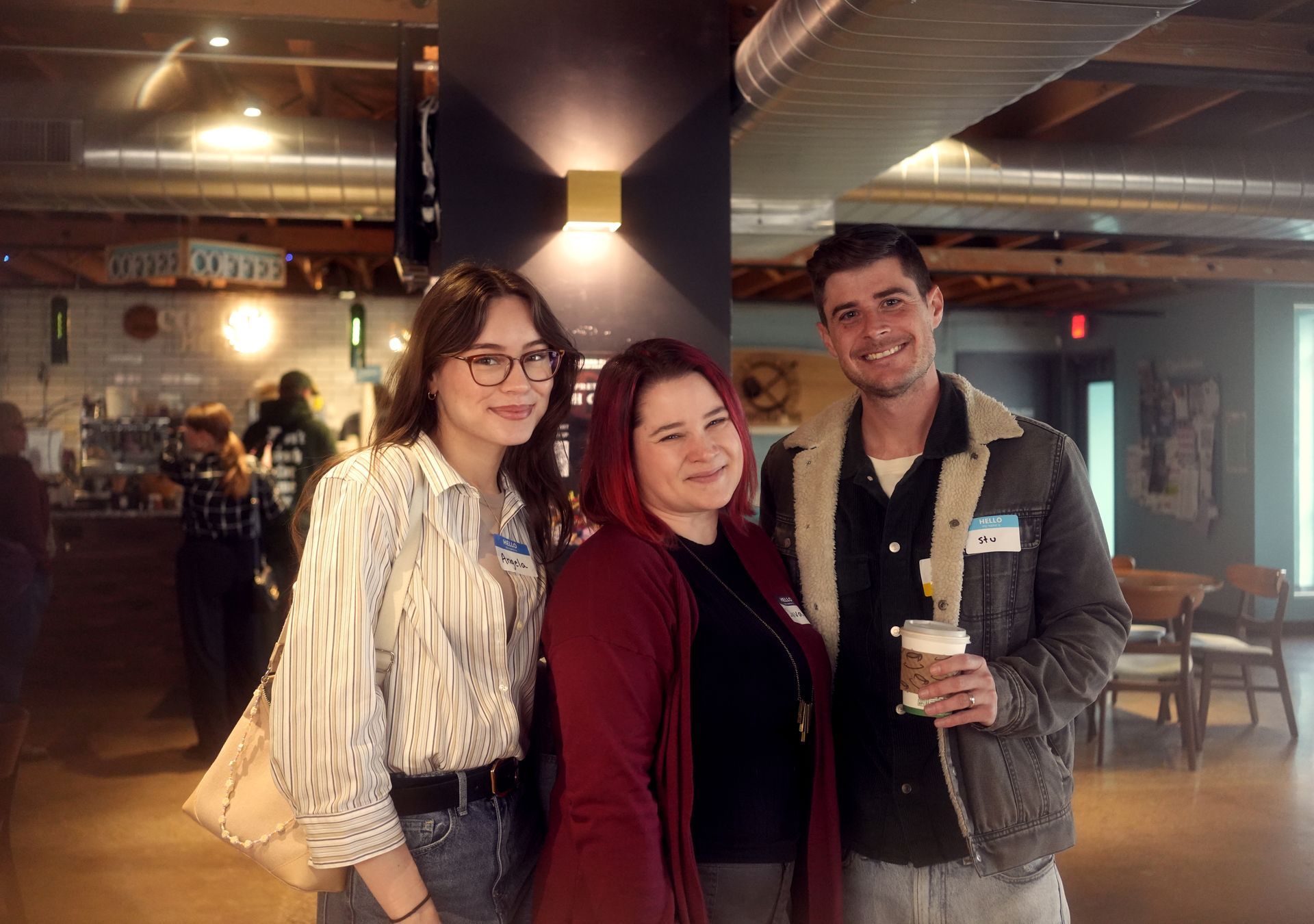 A man and two women are posing for a picture in a restaurant.