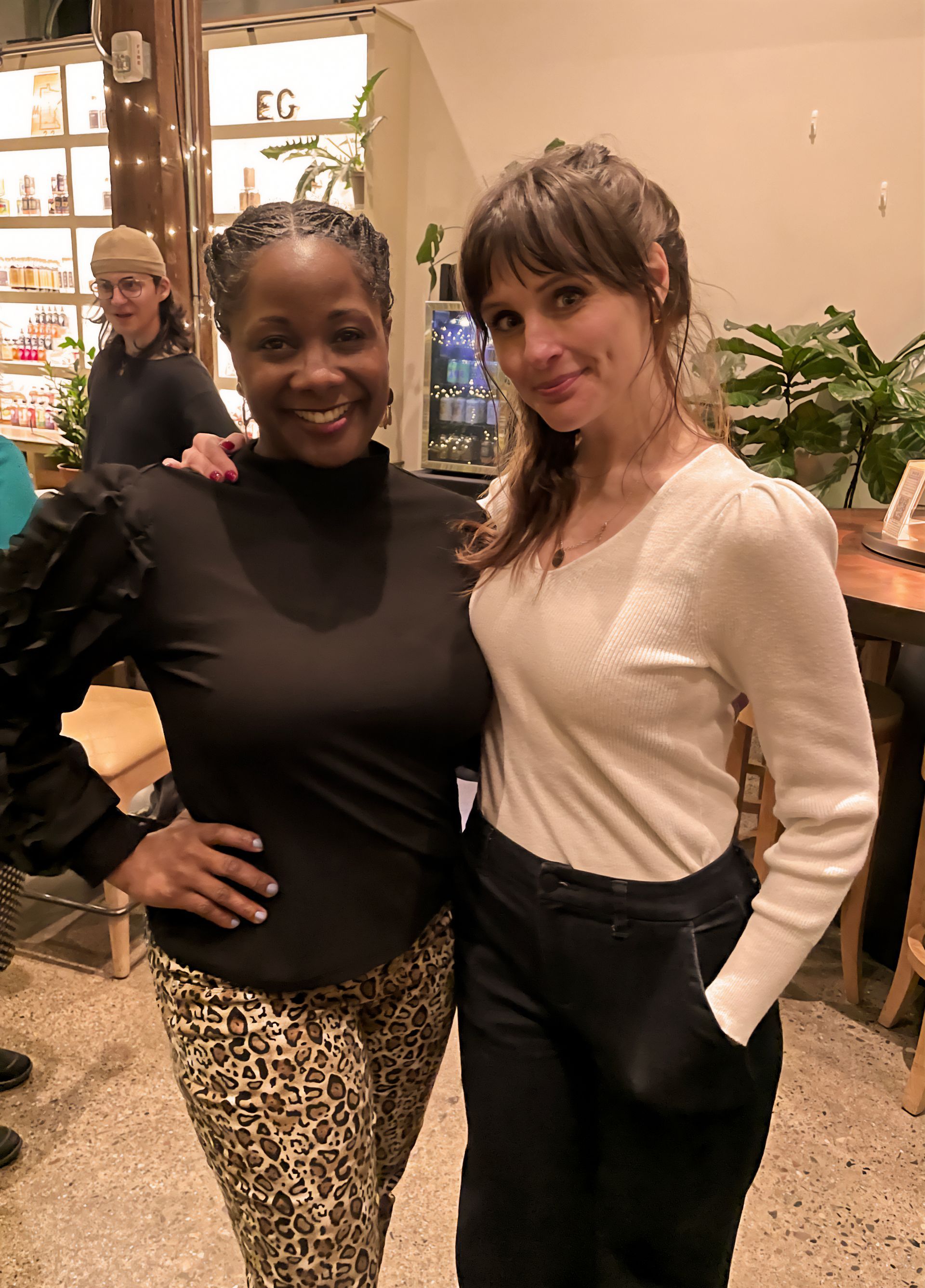Two women are posing for a picture together in a room.