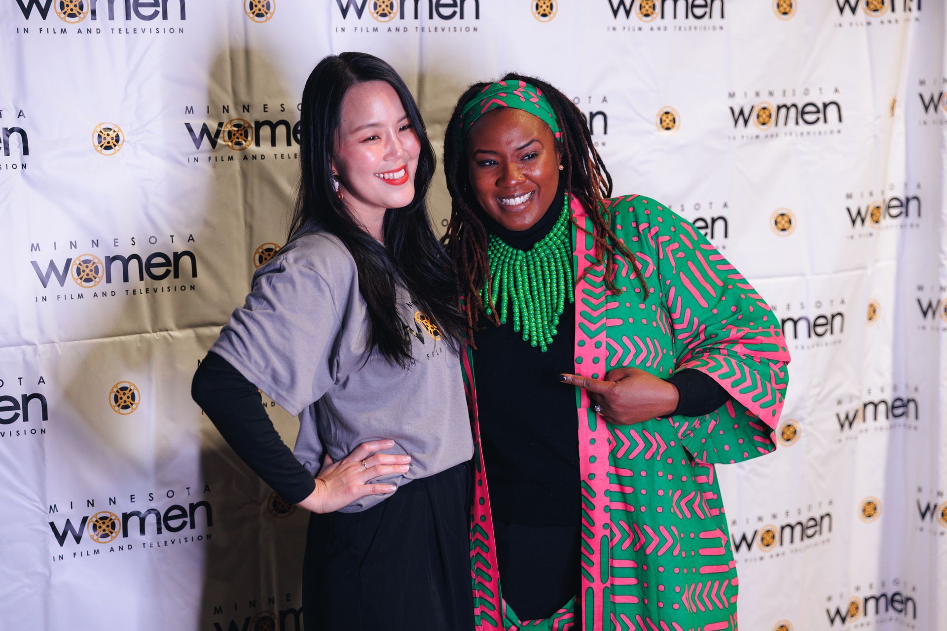 A group of people are standing around a table talking to each other in a black and white photo.