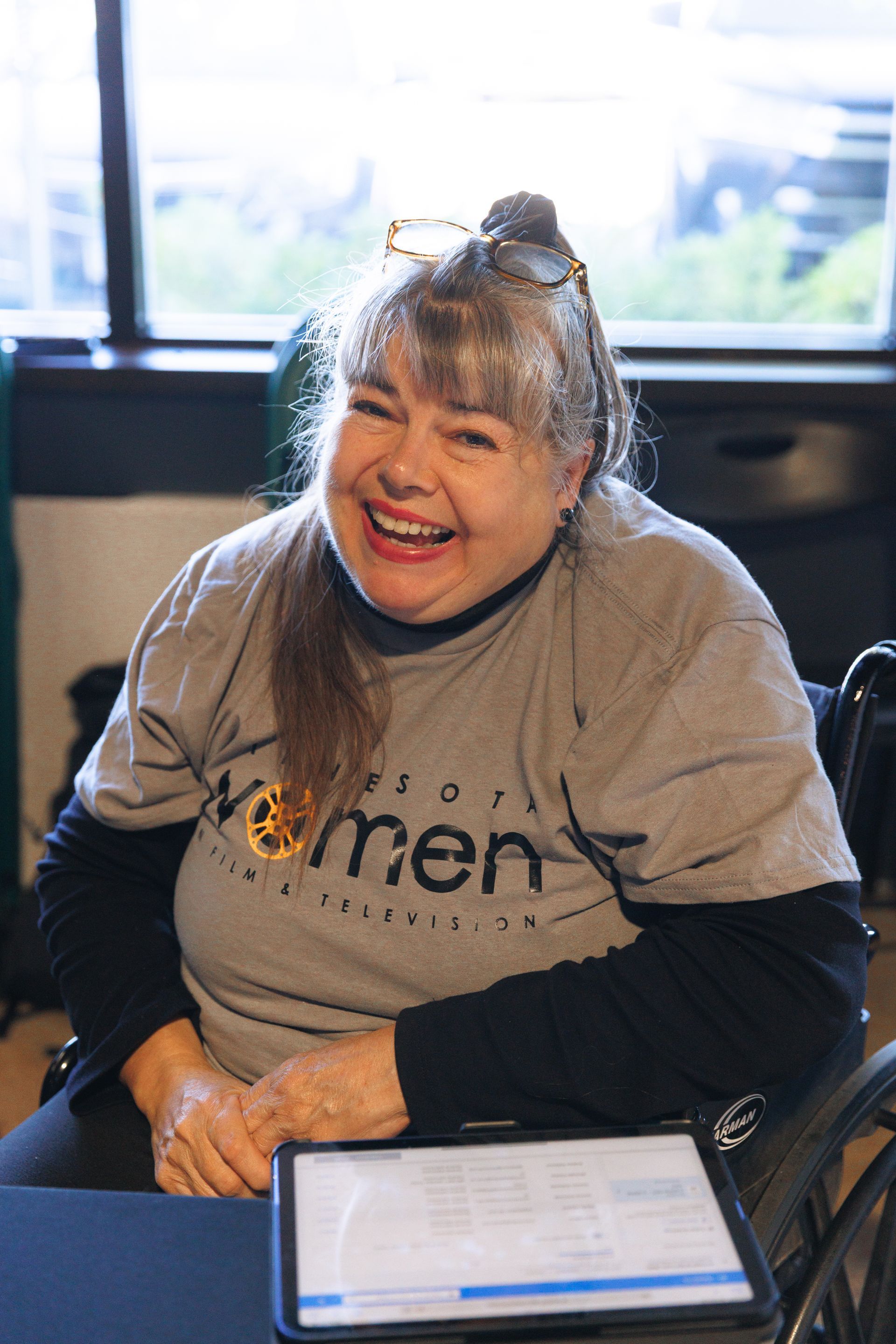 A group of people are standing around a table holding a pizza box.