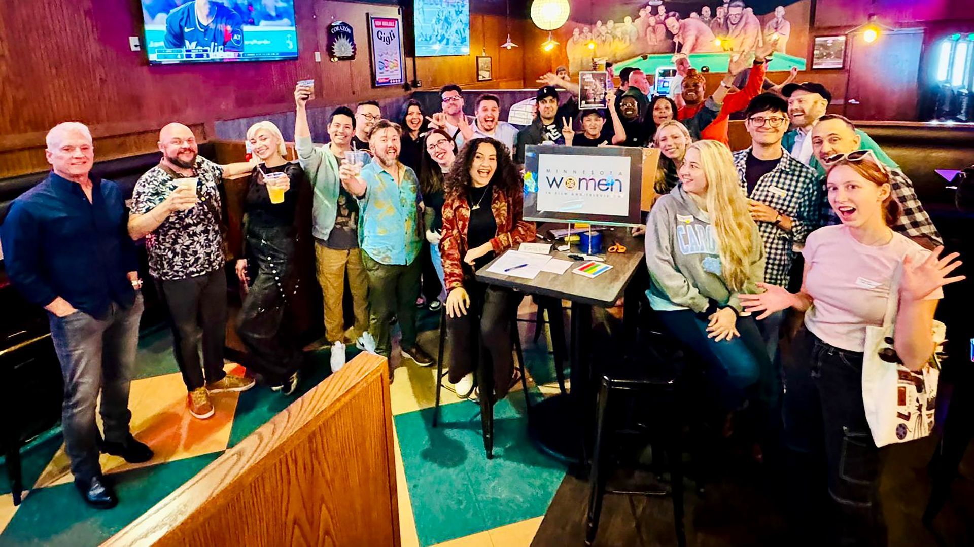A group of people are posing for a picture in a bar.