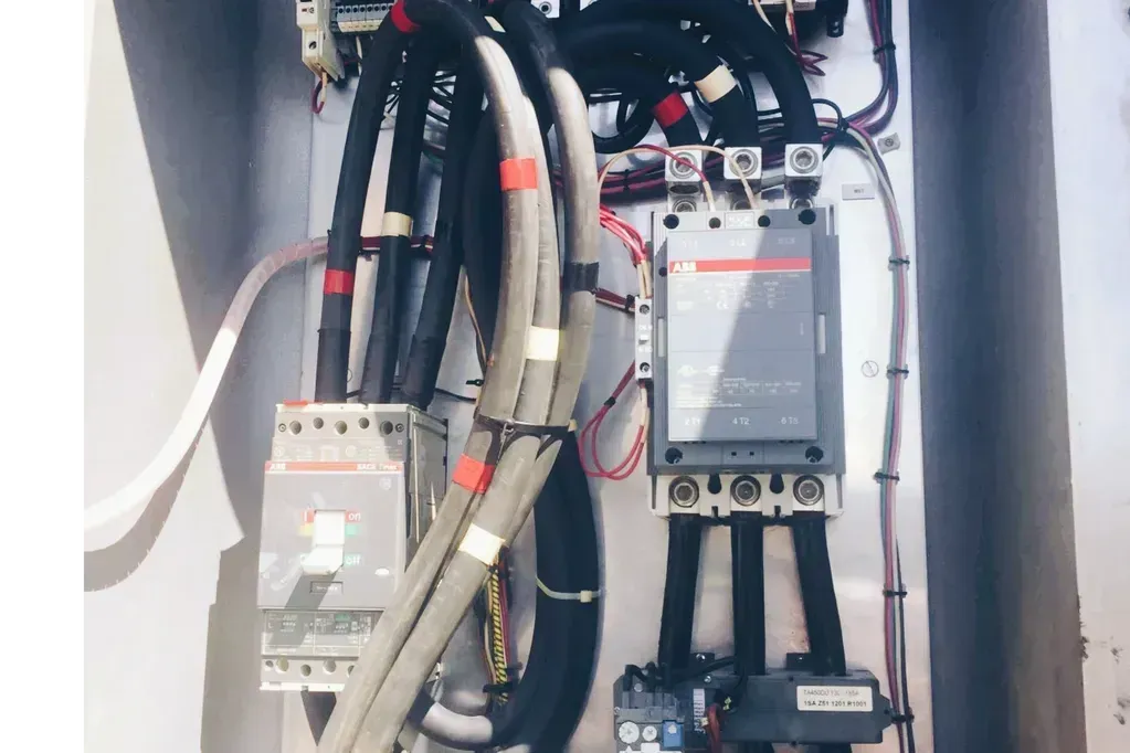 A close up of a electrical box with a lot of wires coming out of it.