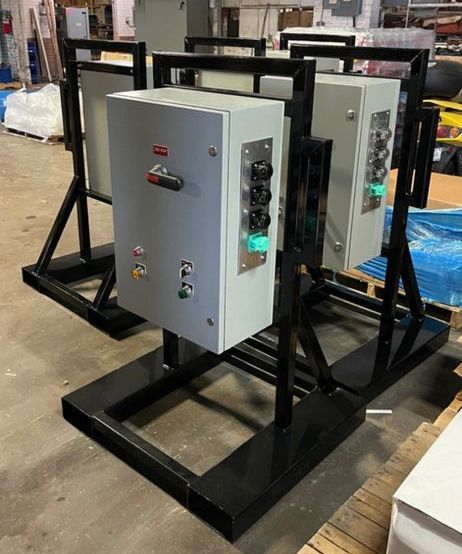 A row of electrical boxes sitting on top of a metal stand.