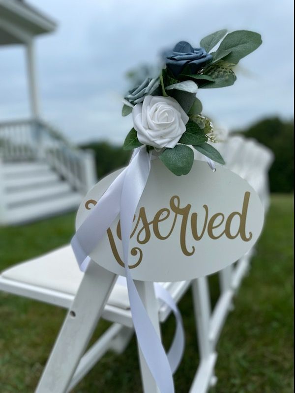 A white chair with a reserved sign on it
