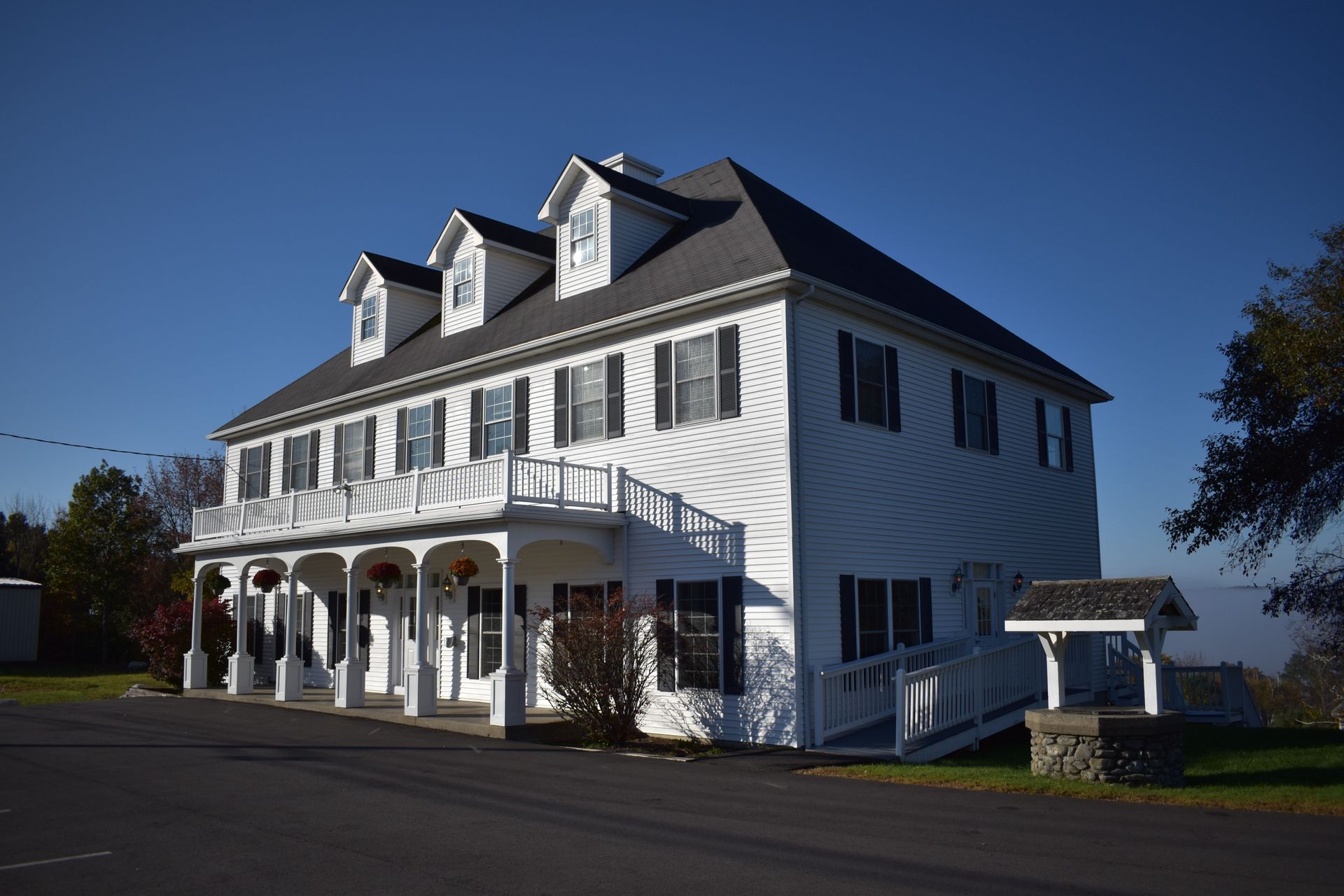 A large white house with black shutters and a porch