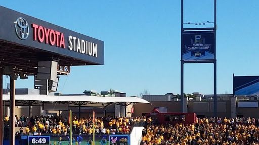 Toyota Stadium: Exterior view with crowd in yellow cheering under a blue sky.