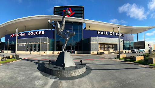 National Soccer Hall of Fame building with a soccer player statue in the foreground.