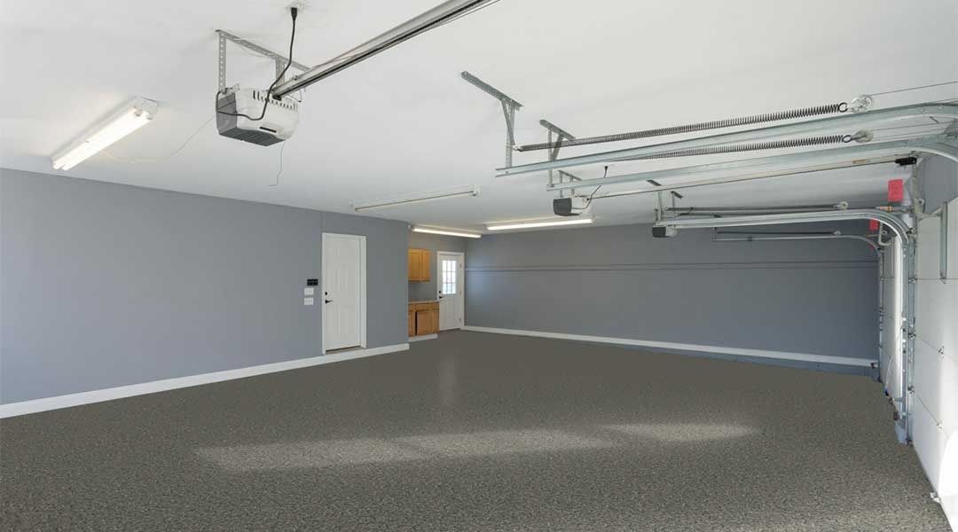 Empty garage with gray walls, flooring, and white ceiling, door, and garage door.