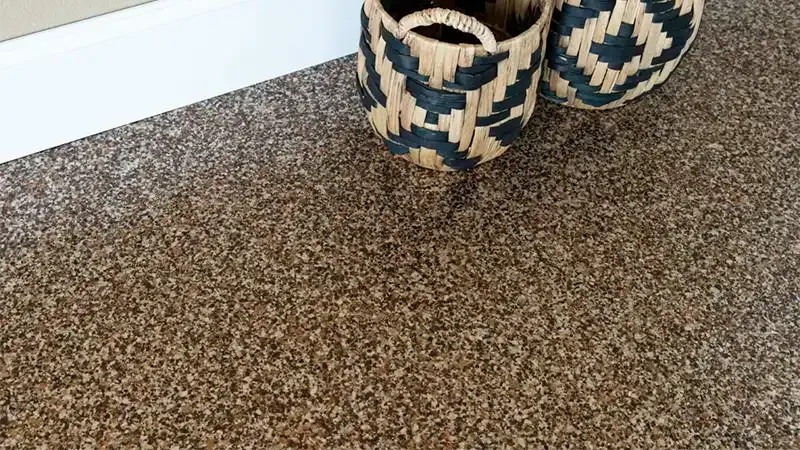Woven baskets with geometric patterns on brown carpet next to white trim.