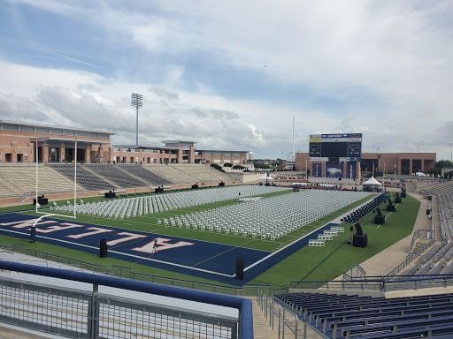Allen High School graduation setup in a football stadium; rows of chairs on the field, stage at the end.