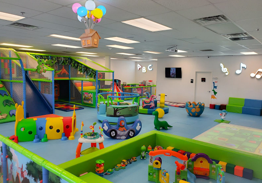 Indoor children's play area with colorful structures, toys, and a floating house with balloons.