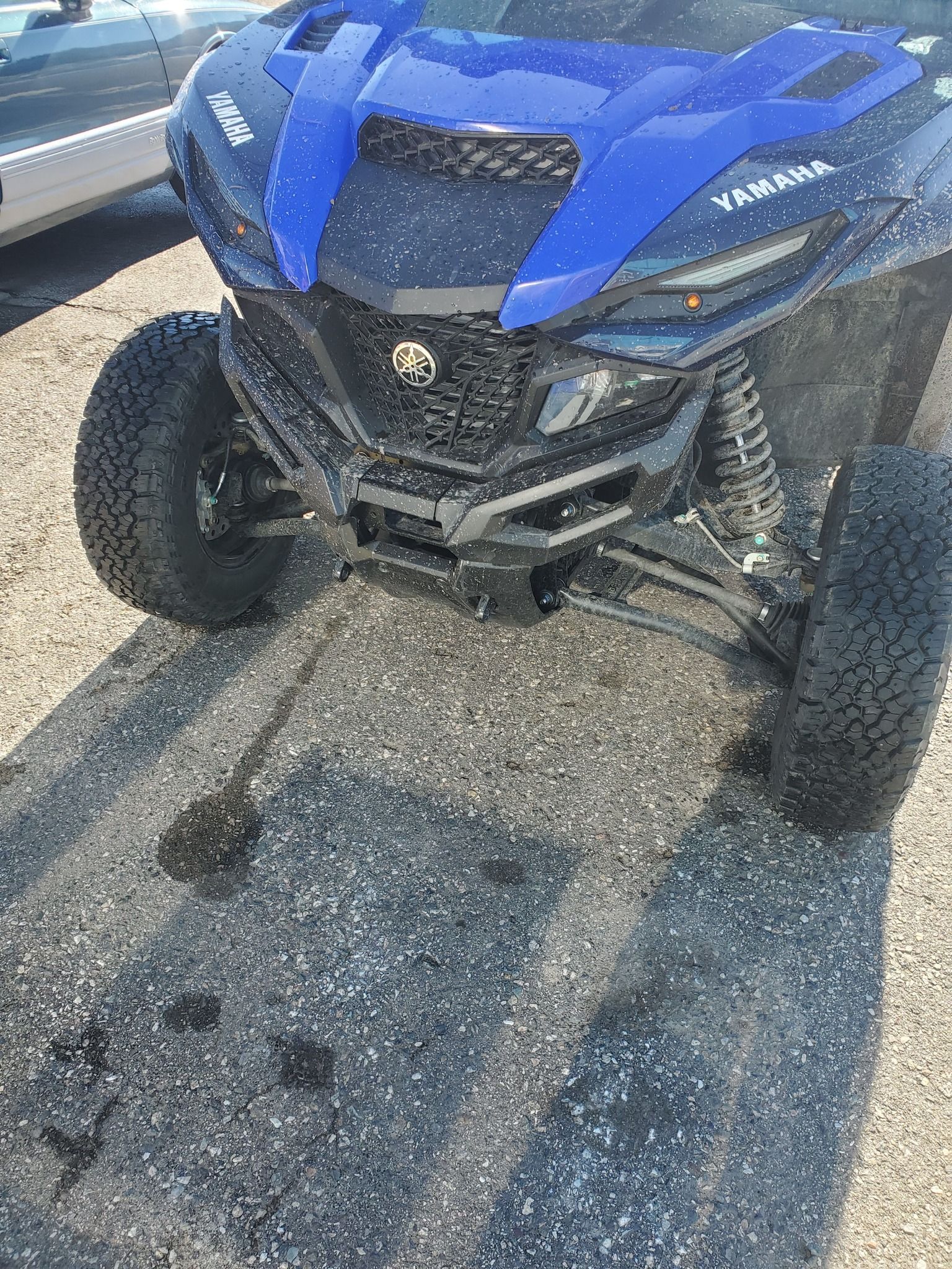 A blue atv is parked on the side of the road.