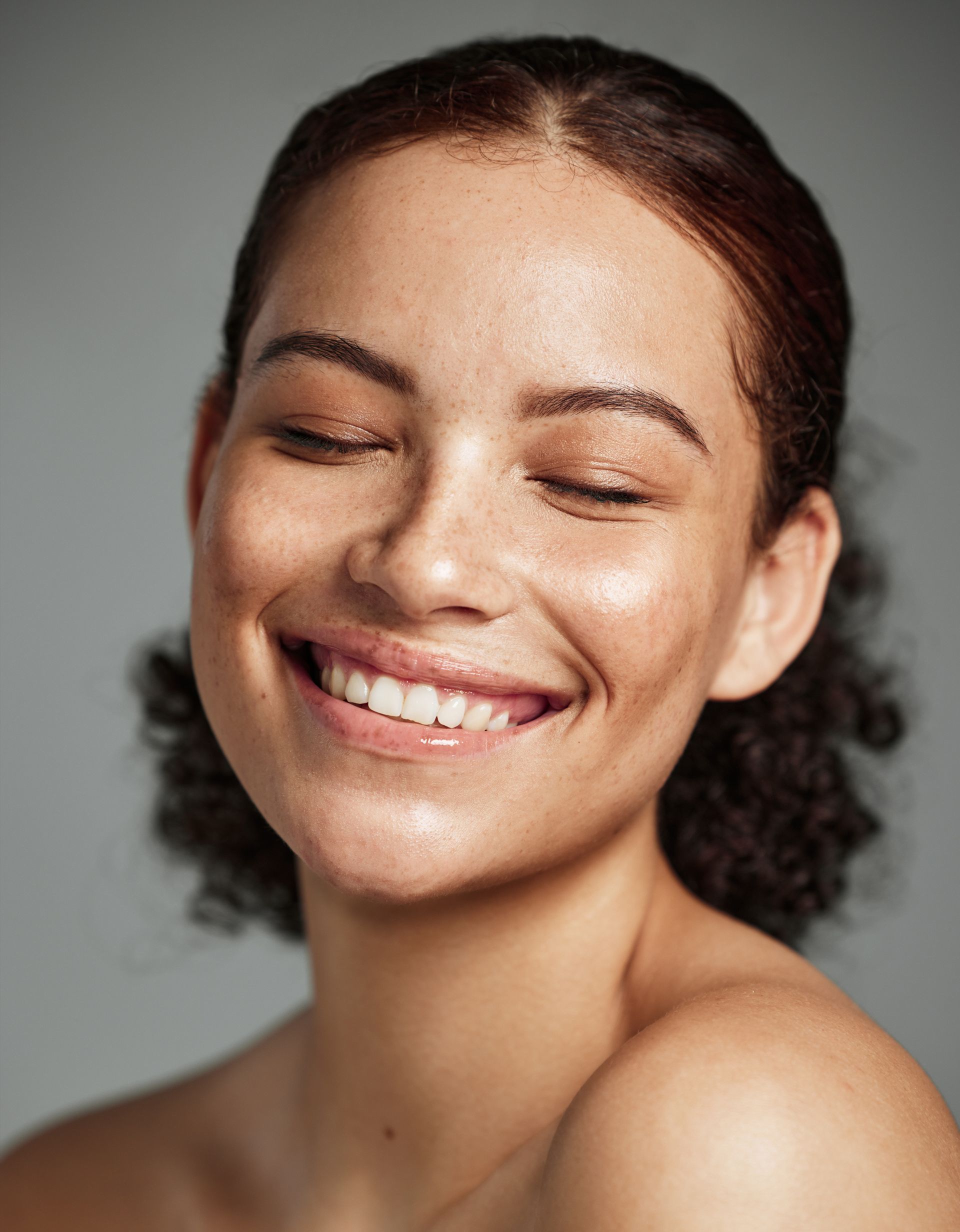smiling young woman with freckles and curly hair