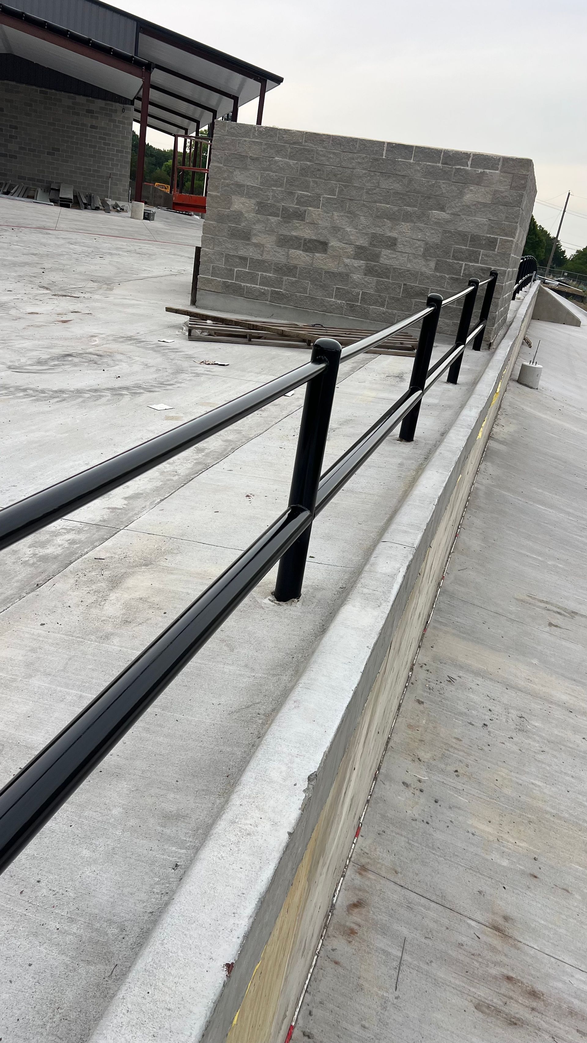 Black metal railing on concrete embankment.