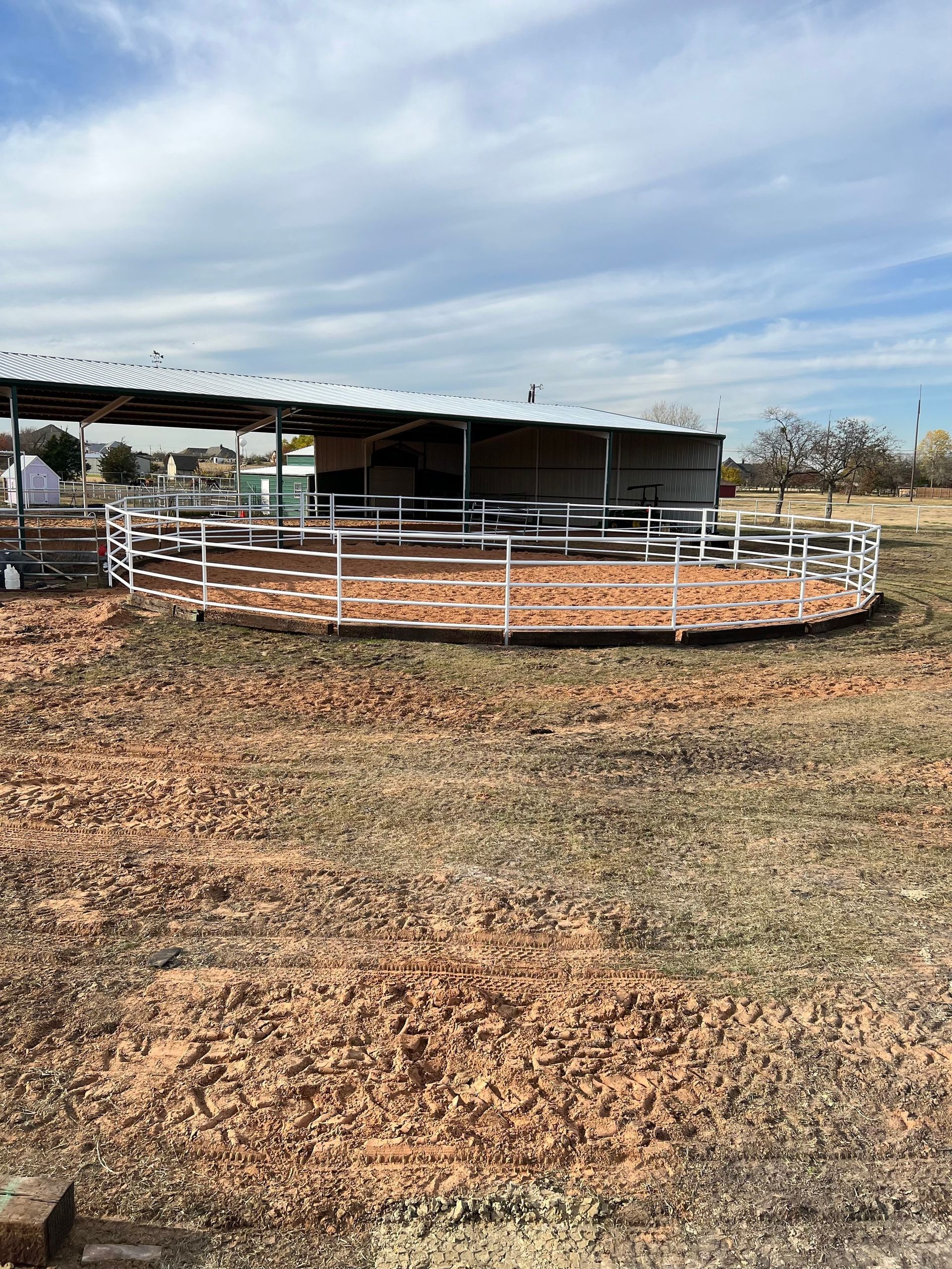 A round pen with a fence around it in a field.