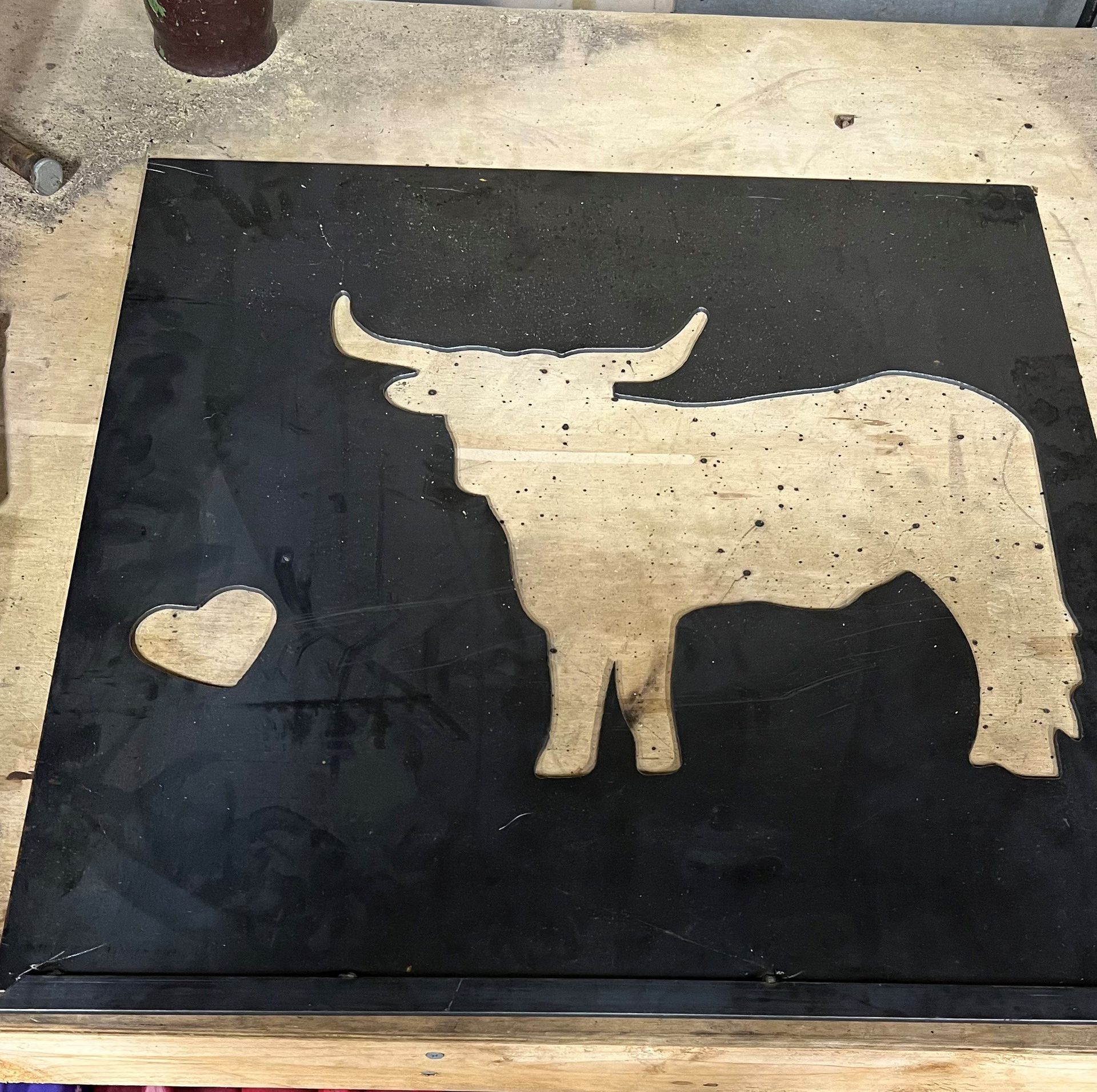 A silhouette of a bull with horns on a black surface