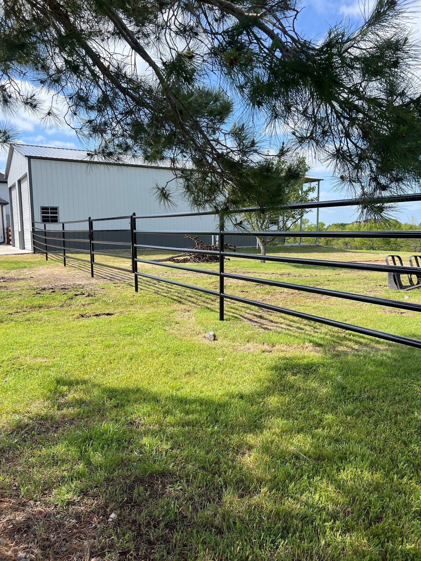 There is a fence in the middle of a grassy field.