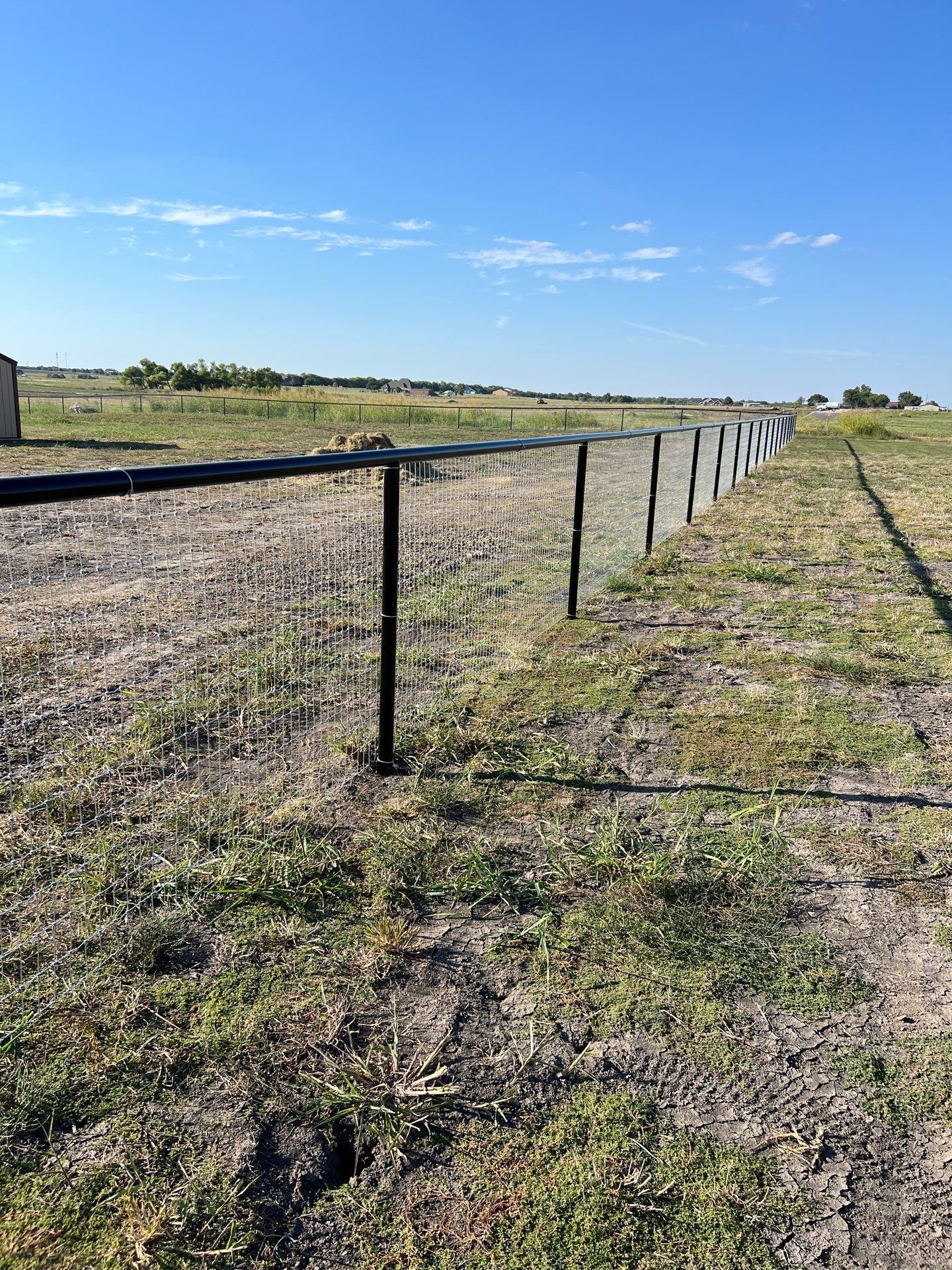 There is a fence in the middle of a field.