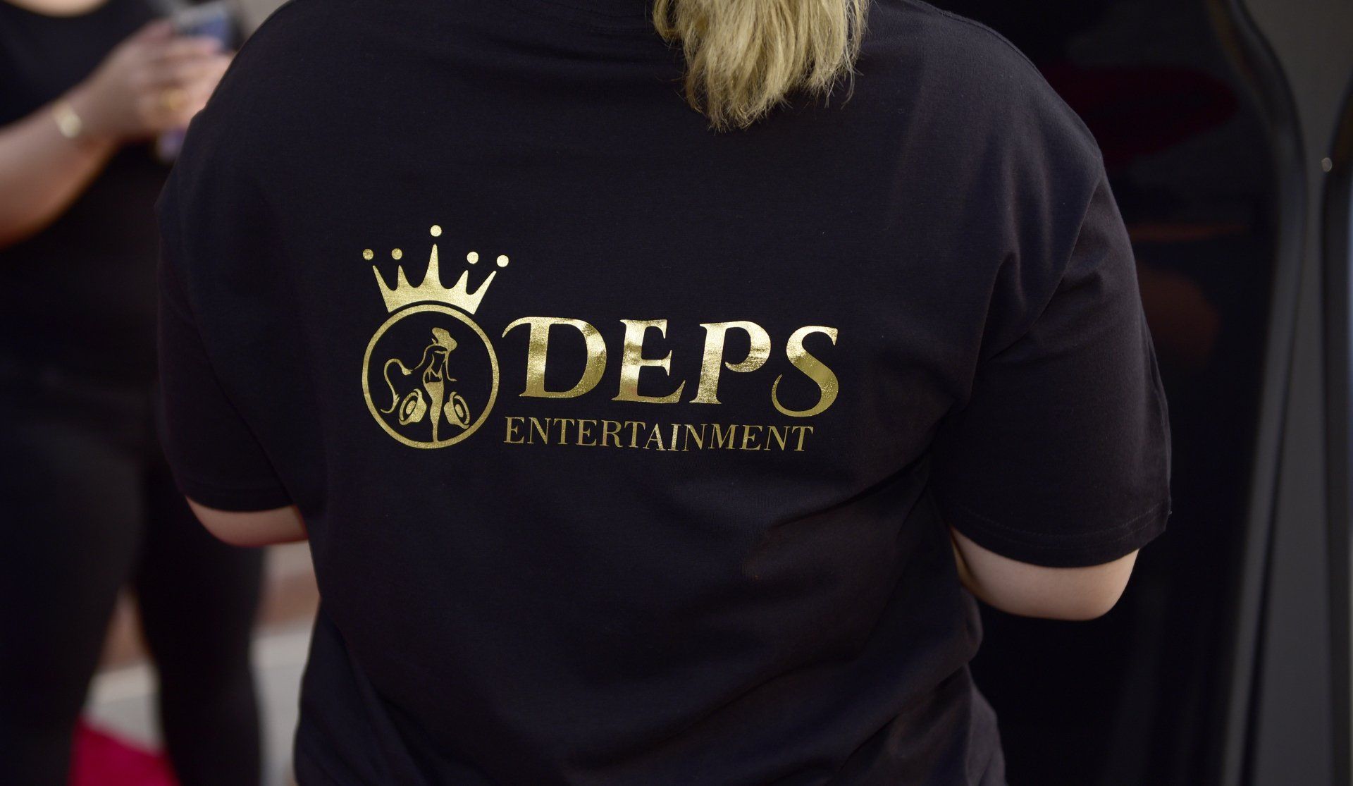 Back of a DEPS employee in a black DEPS t-shirt