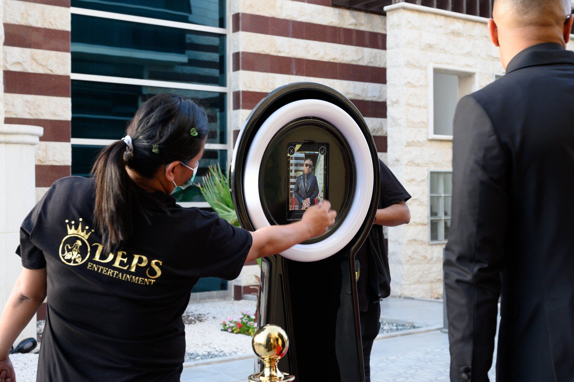 DEPS employee giving operational instructions to a photo booth user