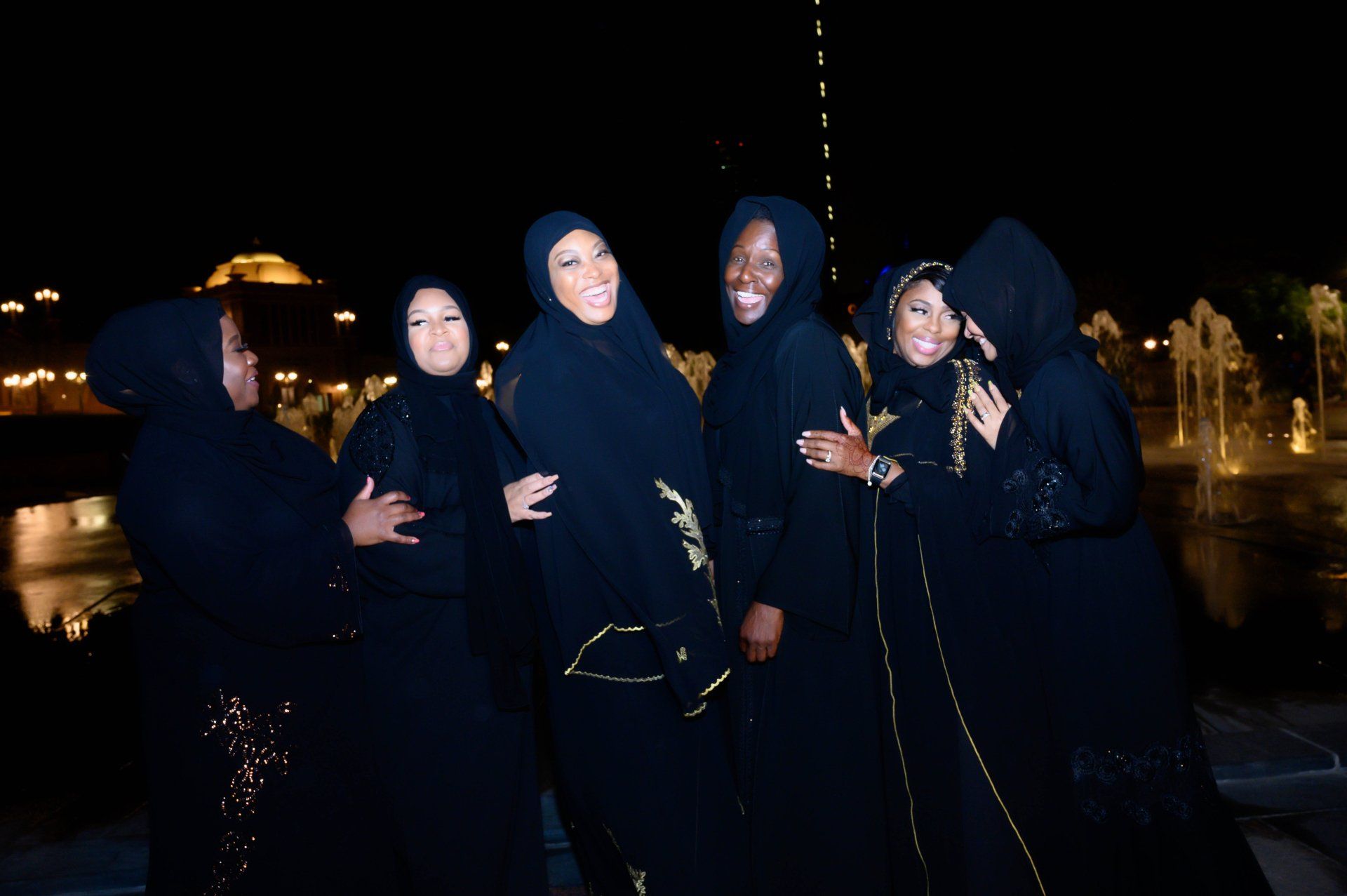 Approximately 5 women on black robes laughing
