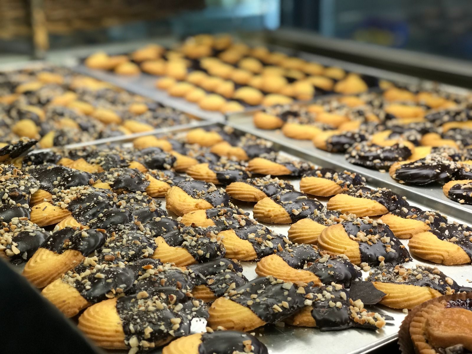 Biscotti su vassoi, alcuni con cioccolato e noci.