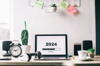 A work space displaying a desk, computer and the current year.