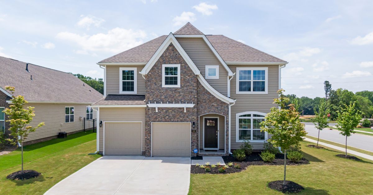 A large house with two garages and a driveway in a residential area.