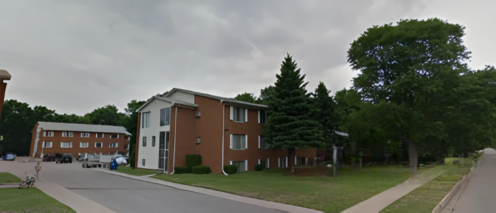 A row of apartment buildings with trees in the background