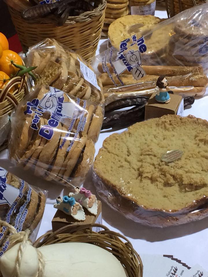 Un tavolo sormontato da una varietà di cibo tra cui biscotti e una torta